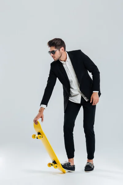 Empresario en gafas de sol y traje va a montar un monopatín — Foto de Stock