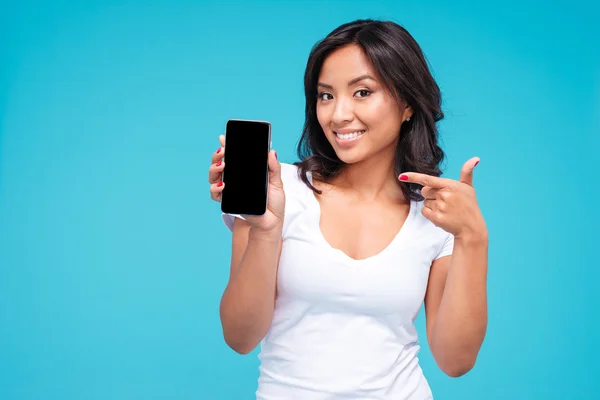 Young vietnamese woman pointing finger on blank smartphone screen — Stock fotografie