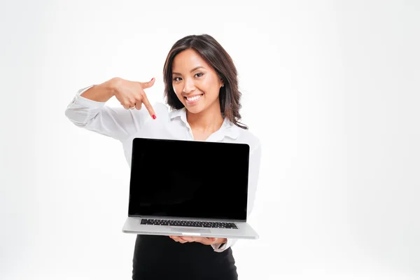Lächelnde asiatische Geschäftsfrau zeigt auf Laptop mit leerem Bildschirm — Stockfoto