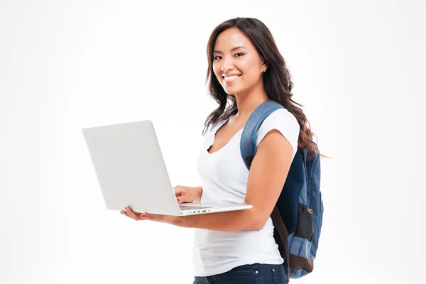 Šťastná Asijská studentka s batohu na sobě a držící notebook — Stock fotografie