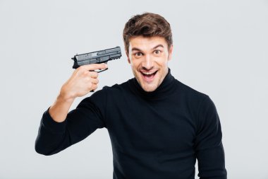 Çılgın neşeli genç adam silahını Tapınağı ve gülüyor