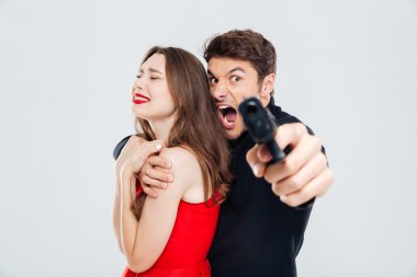 Kadın tutarak ve seni silahla işaret eden öfkeli adam