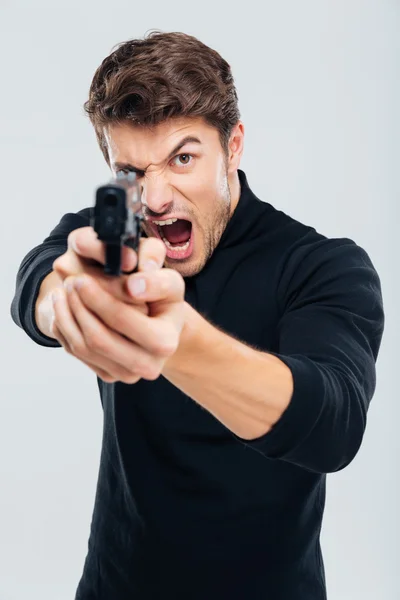 Wütender irritierter junger Mann richtet Waffe auf dich und schreit — Stockfoto