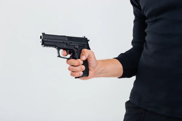 Gros plan de l'homme en vêtements noirs tenant une arme — Photo