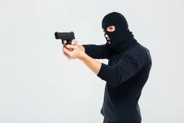 Homem criminoso em Balaclava de pé e apontando com arma — Fotografia de Stock