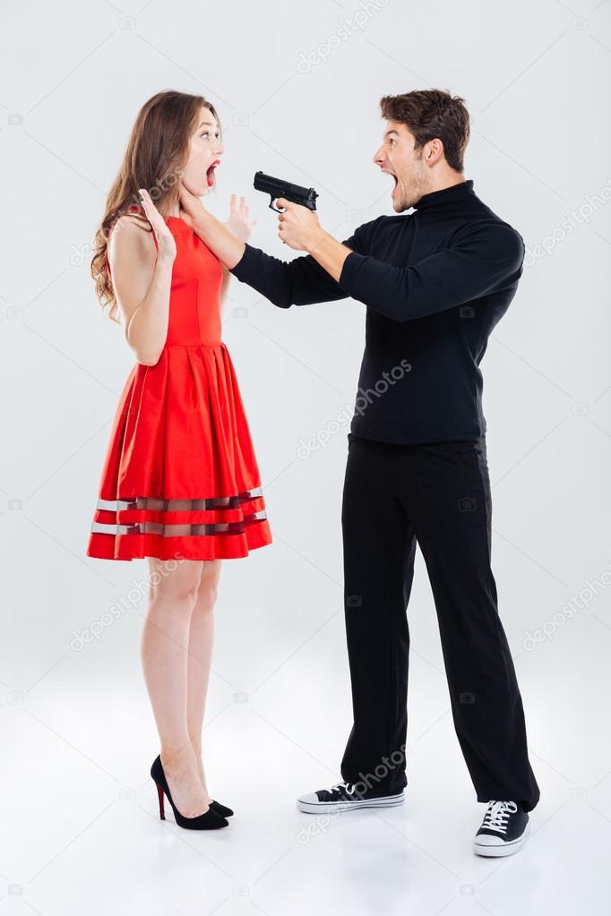 Criminal man choking and threatening with gun to woman