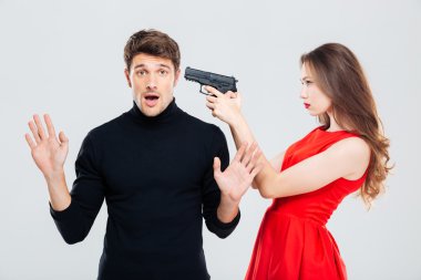 Ayakta ve korkmuş genç adam silahla tehdit eden kadın