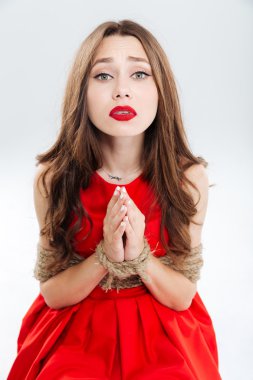 Kadın oturuyor ve yardım için yalvarıyor halatlar ile sınırlı