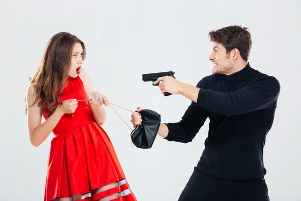 Man theif stealing young woman bag and threatening with gun — Stock Photo, Image