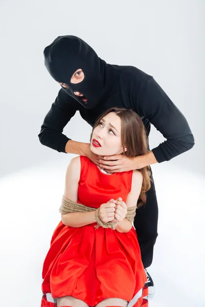 Scared woman bounded with ropes choking by man in balaclava — Stock Photo, Image