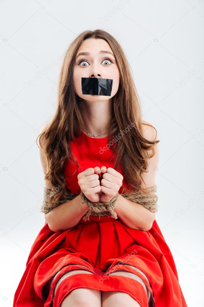 Woman bounded using ropes sitting with closed mouth by tape