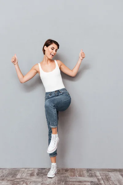 Full längd porträtt av leende kvinna med upphöjda händer upp — Stockfoto