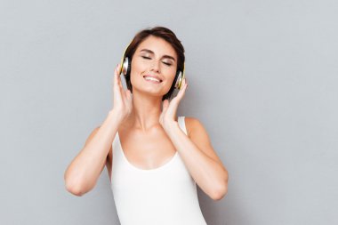 Kulaklıkla müzik dinleyen neşeli, gülümseyen güzel kadın