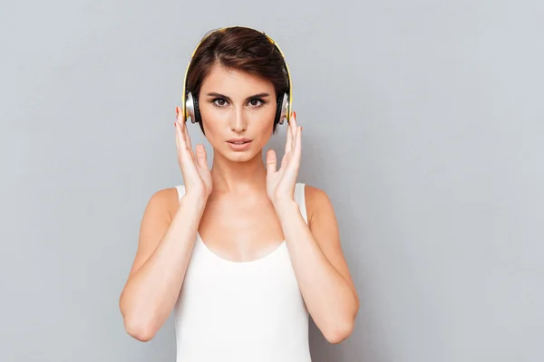 Retrato de una mujer concentrada pensativa escuchando música en auriculares —  Fotos de Stock