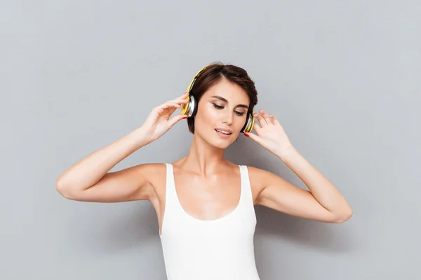 Hermosa joven morena escuchando música con auriculares — Foto de Stock