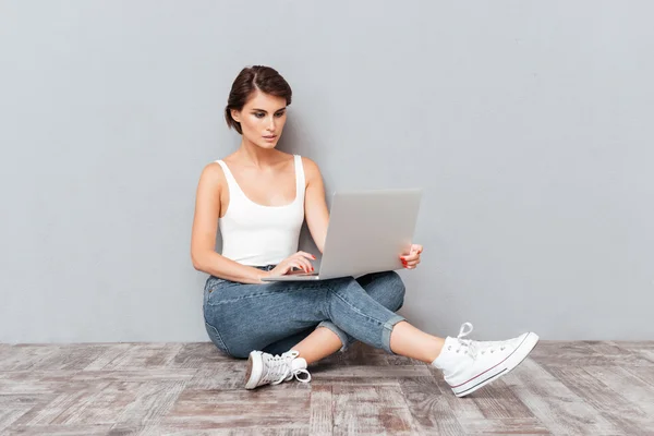 Ritratto di una giovane ragazza bruna pensosa che utilizza il computer portatile — Foto Stock