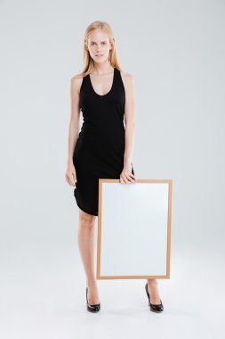 Boş tahta tutan güzel bir kadının tam uzunlukta portre