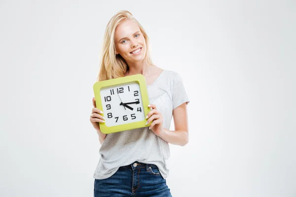 Feliz joven mujer de pie y sosteniendo reloj de pared — Foto de Stock