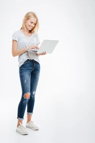 Dizüstü bilgisayar kullanan mutlu bir kadın portresi tam uzunlukta — Stok fotoğraf