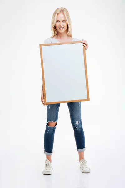 Retrato de comprimento total de uma mulher sorridente segurando placa em branco — Fotografia de Stock