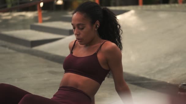 Eine Ruhige Junge Afroamerikanerin Mit Kopfhörern Sitzt Auf Der Yogamatte — Stockvideo