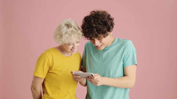 Emocional Jovem Irmã Irmão Estão Assistindo Algo Smartphone Isolado Sobre — Vídeo de Stock