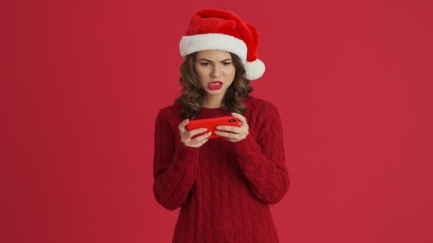 Een Lachende Vrouw Met Een Warme Rode Trui Kerstmuts Speelt — Stockvideo