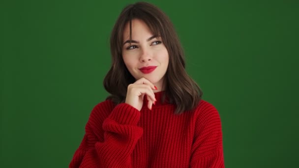 Pleased Woman Red Sweater Thinking Something Standing Isolated Green Background — Stock Video