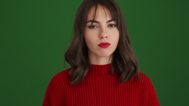 赤いセーターで自信のある女性ありますしています停止ジェスチャー立って隔離された緑の背景 — ストック動画