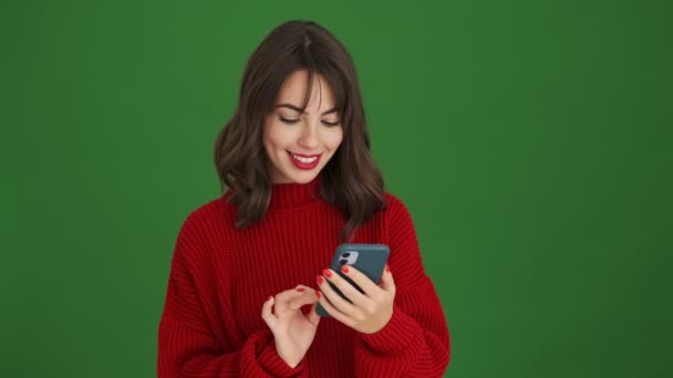 Een Gelukkige Jonge Vrouw Een Rode Trui Praat Haar Smartphone — Stockvideo