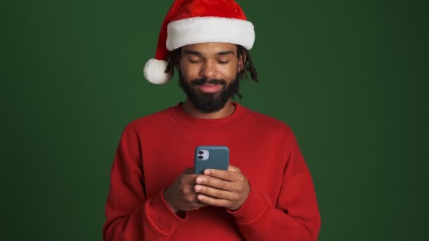 Mladý Šťastný Africký Muž Vánoční Santa Klobouk Pomocí Mobilního Telefonu — Stock video