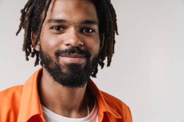 Gri duvar arkasında izole edilmiş poz veren memnun bir Afrikalı adamın resmi