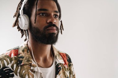 Kulaklıkla müzik dinleyen siyahi bir gencin portresi.