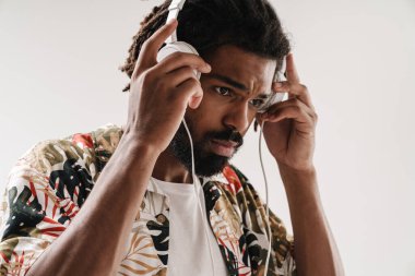 Kulaklıkla müzik dinleyen siyahi bir gencin portresi.
