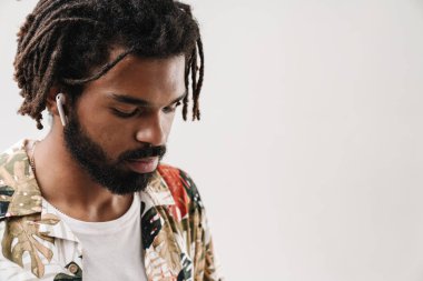 Kulaklıkla müzik dinleyen ciddi bir siyahi adamın portresini yakından çek.