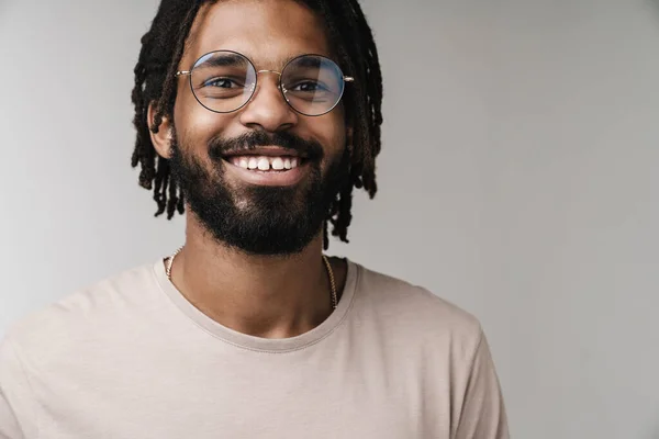 幸せな正のアフリカ人の男のイメージは 眼鏡で灰色の壁の背景に隔離されたポーズ — ストック写真