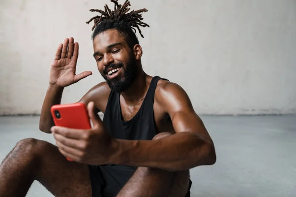 非洲裔美国运动员在室内用手机挥手的照片 — 图库照片