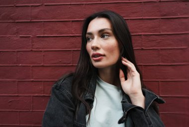 Dışarıda yürüyen ve başka tarafa bakan güzel bir genç kadın görüntüsü