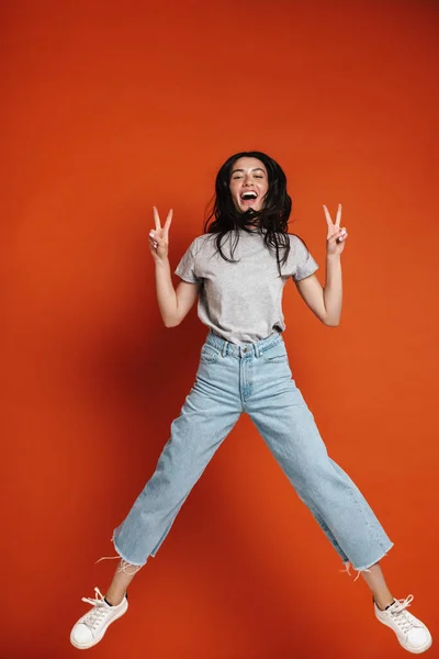 Imagen Una Joven Mujer Feliz Saltando Mostrando Signo Paz Aislado —  Fotos de Stock