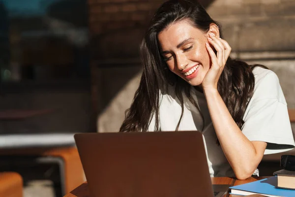 照片中快乐快乐的年轻女子在户外用手提电脑在咖啡馆里 — 图库照片