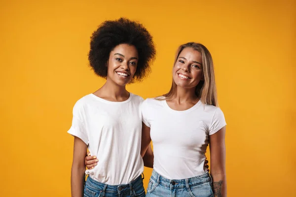 黄色の壁の背景の上に隔離されたポーズをとる陽気な正の若い多人種の女の子の友人のイメージ — ストック写真
