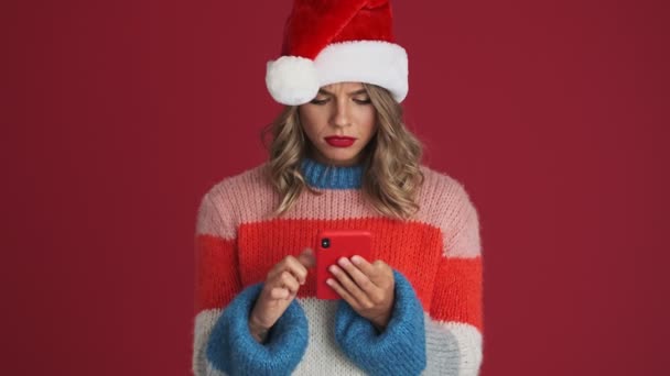 Νεαρή Θλιβερή Γυναίκα Στα Χριστούγεννα Καπέλο Σάντα Χρησιμοποιώντας Κινητό Τηλέφωνο — Αρχείο Βίντεο