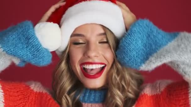 若いです幸せなチェリー可愛いです女性でクリスマスサンタ帽子孤立以上赤壁の背景 — ストック動画