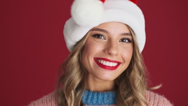 Jonge Glimlachende Grappige Vrouw Kerst Santa Hoed Geïsoleerd Rode Muur — Stockvideo