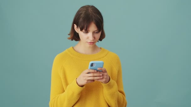Soustředěná Žena Používá Svůj Smartphone Stojící Izolovaně Nad Modrým Pozadím — Stock video