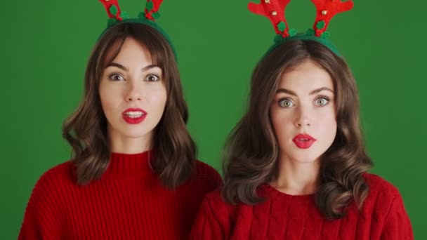 Close View Surprised Girls Wearing Christmas Reindeer Antlers Red Sweaters — Stock Video