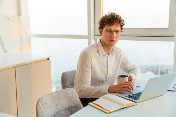 Впевнений Привабливий Молодий Бізнесмен Білій Сорочці Працює Ноутбуці Сидячи Столом — стокове фото