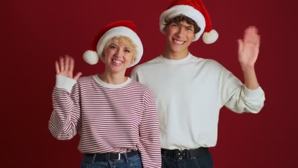 Joven Chica Feliz Con Hermano Navidad Sombrero Santa Saludando Usted — Vídeo de stock