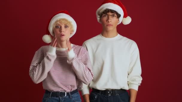 Joven Sorpresa Sorprendió Chica Con Hermano Navidad Sombrero Santa Aislado — Vídeo de stock