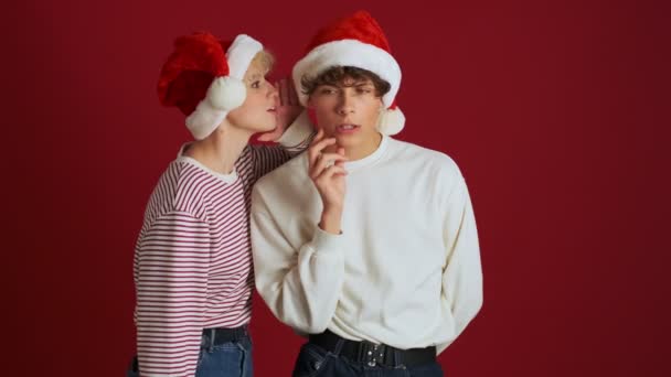 Joven Chica Positiva Chismorreando Con Hermano Navidad Sombrero Santa Aislado — Vídeo de stock